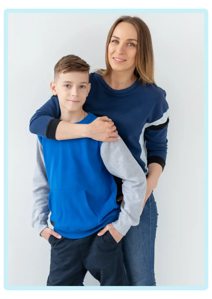 Woman embracing a young boy, both smiling together