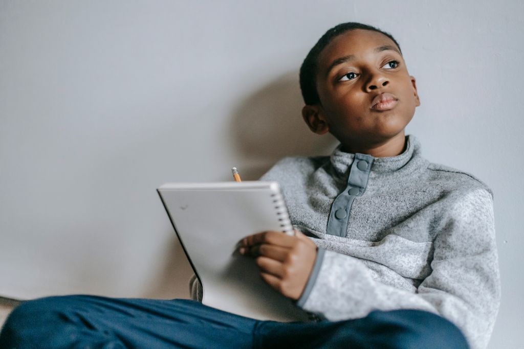 Child holding tablet thoughtfully