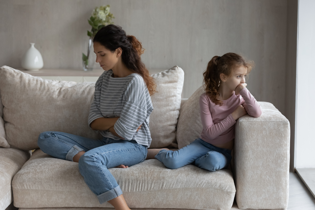 Mother sitting with upset child on couch