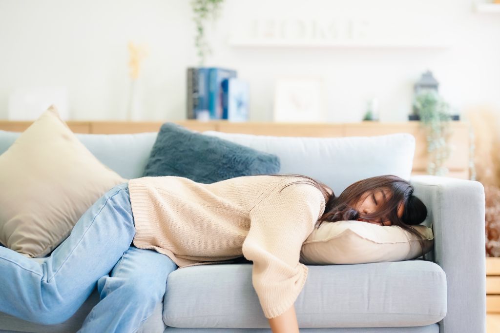 Person relaxing under blanket on couch