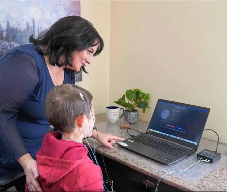 Therapist and child during neurofeedback brain training session at computer