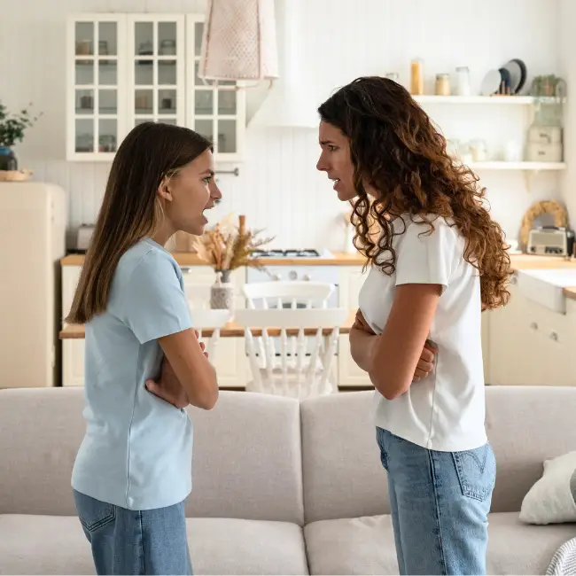 Two children sitting face-to-face on couch having conversation