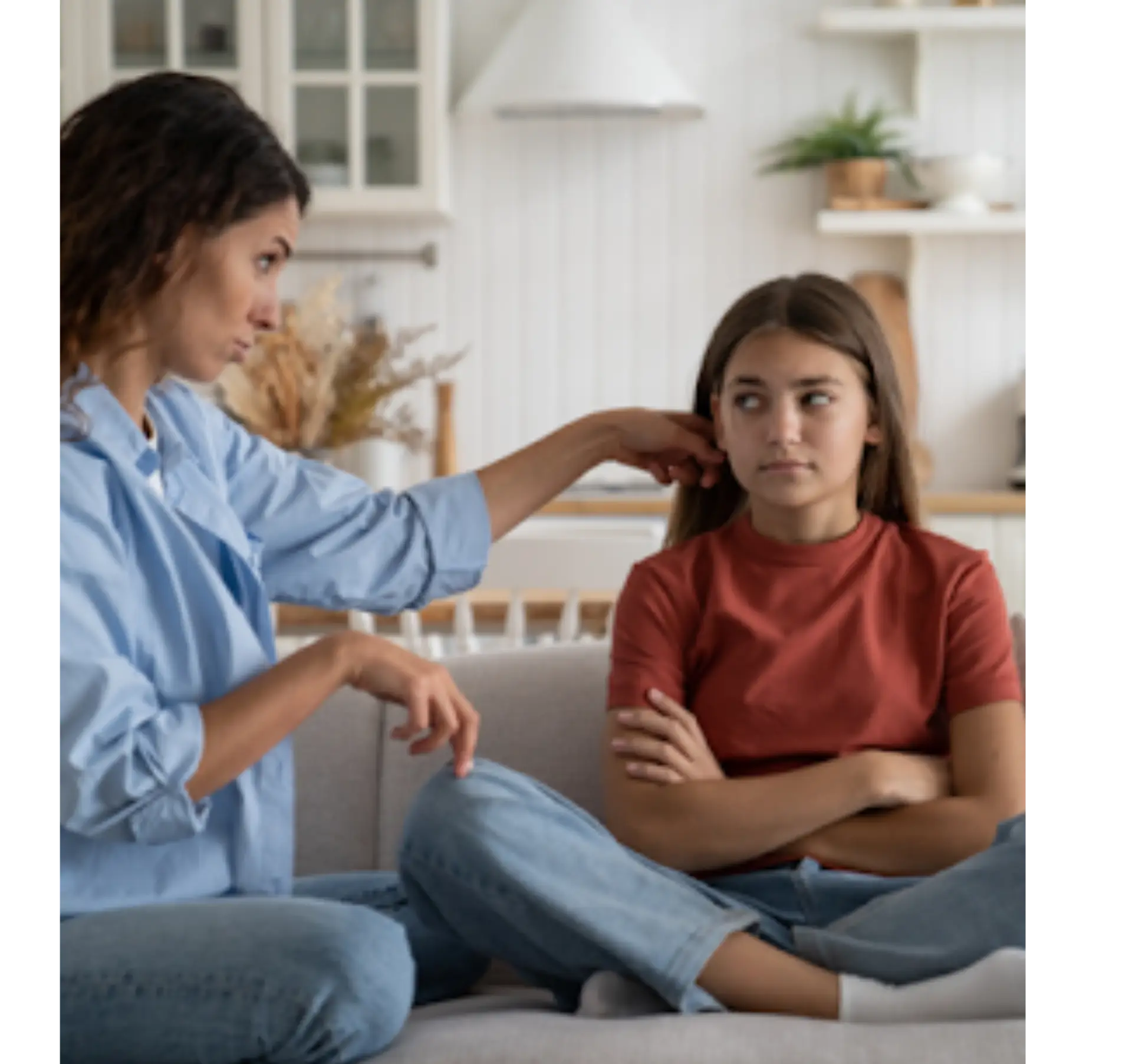 Woman and teen having supportive conversation on couch
