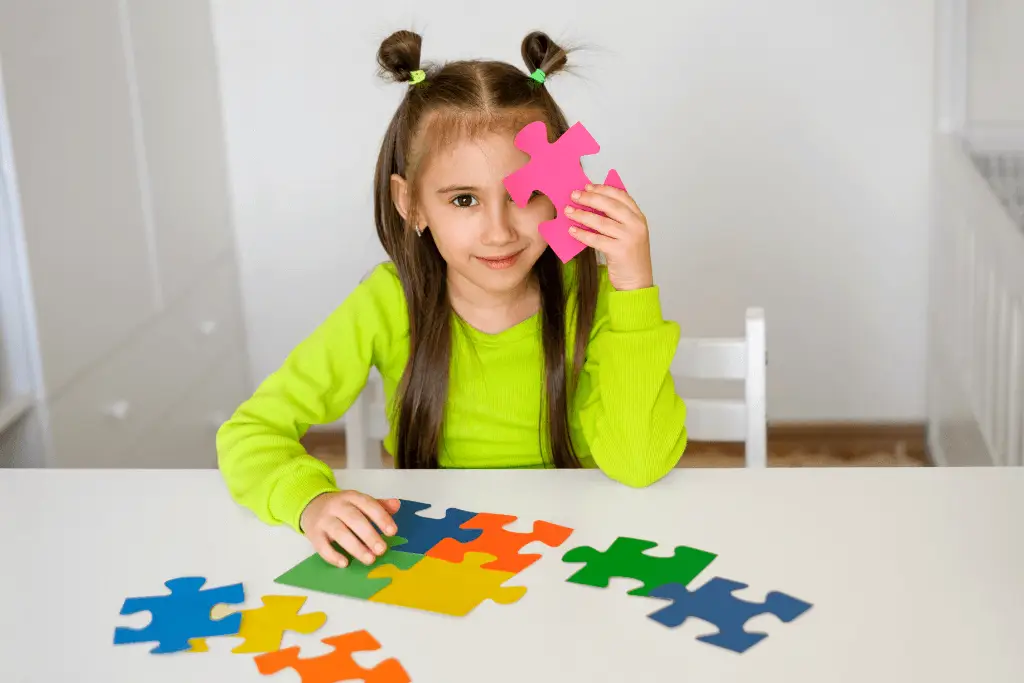Girl holding pink puzzle piece near face symbolizing autism awareness