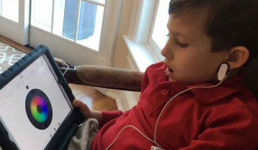Young person using biofeedback device with colorful visual display