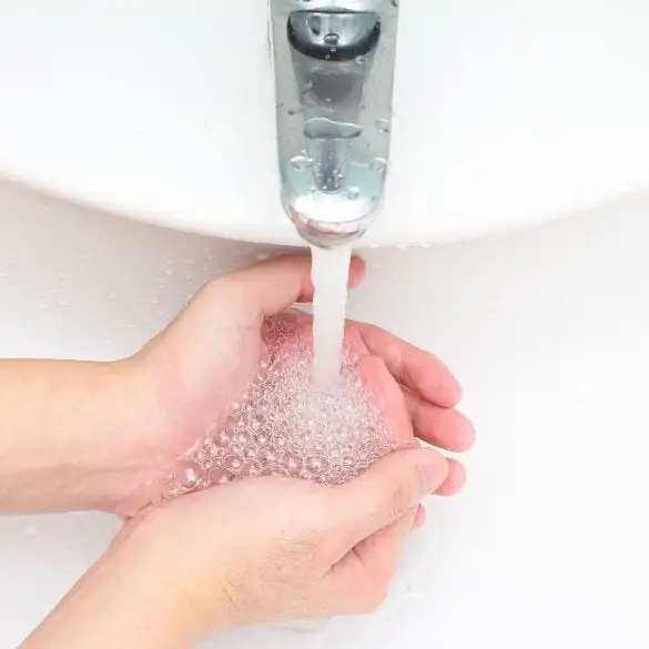 Child's hands using foam hand soap dispenser