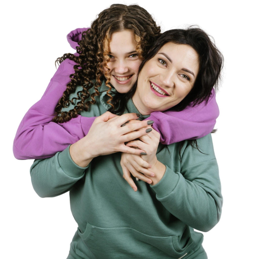 Adult hugging child from behind, both smiling