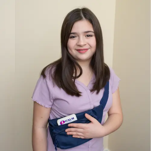 Young person in purple top wearing blue CALM fanny pack, smiling