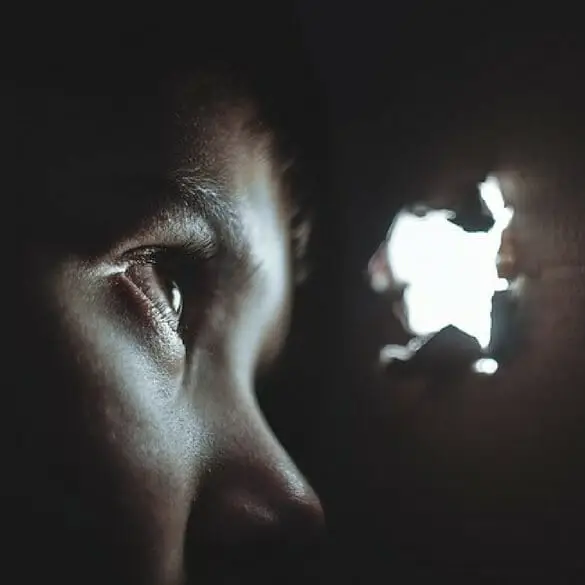 Person showing expression of fear against dark background