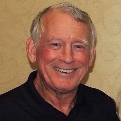Older man smiling in professional headshot